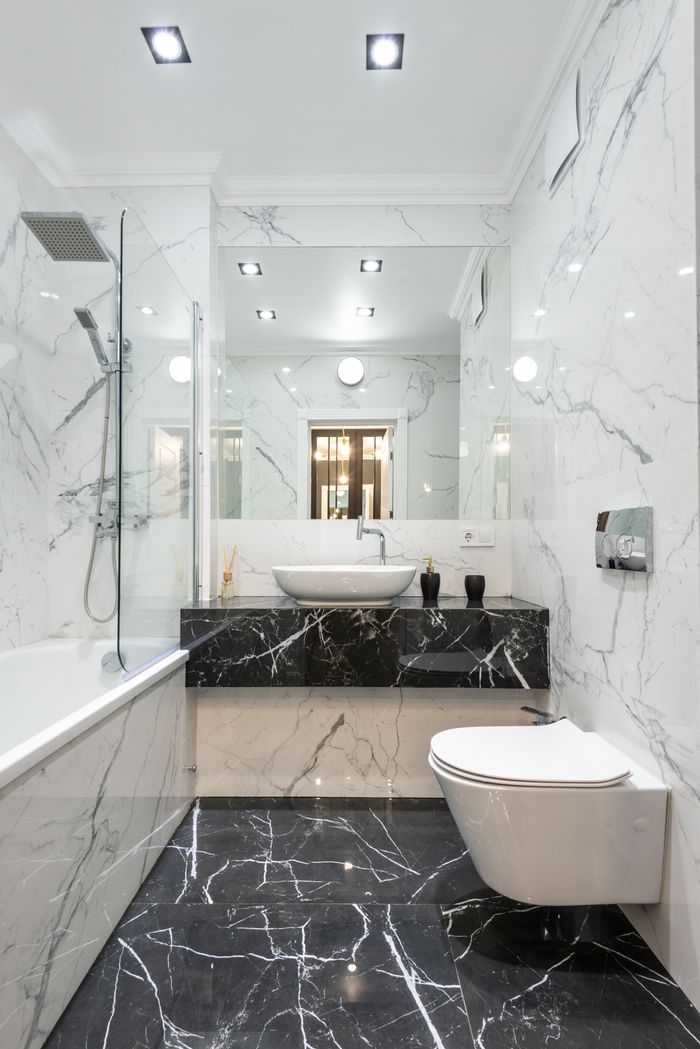 Luxurious bathroom featuring marble walls and floor with modern fixtures and minimalist design.
